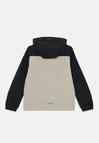 Un giubbotto con cappuccio beige e nero a maniche lunghe, caratterizzato da un design a blocchi di colore. Il materiale sembra liscio con polsini elasticizzati. Logo del marchio sul retro.