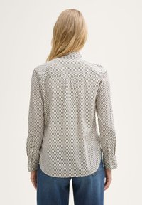 Overhemd met knoopsluiting in een lichtgewicht stof, met een patroon van verticale lijnen in marineblauw en crème. Lange mouwen met knoopmanchetten.
