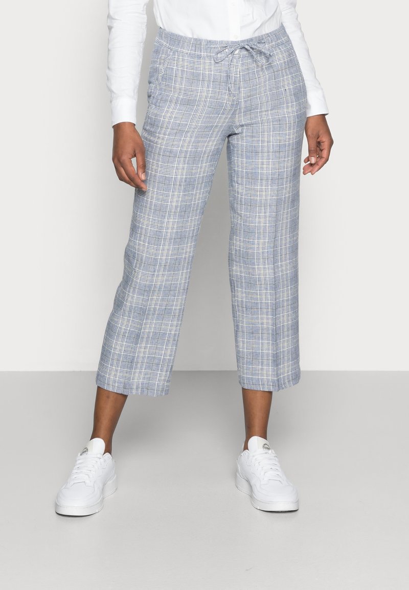 Ljusblå rutiga croppedbyxor med elastisk midja och dragsko. Kombineras med vita sneakers. Mönstret består av korsande linjer.