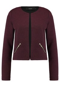 Veste ajustée bordeaux avec une texture côtelée, une patte de boutonnage noire à l'avant et des poches latérales zippées ornées de détails argentés.