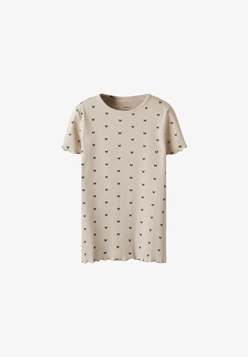 Camiseta corta de manga corta en color beige con una textura acanalada y pequeños patrones de mariposas marrones distribuidos uniformemente por la tela. Dobladillo con forma de ondas.