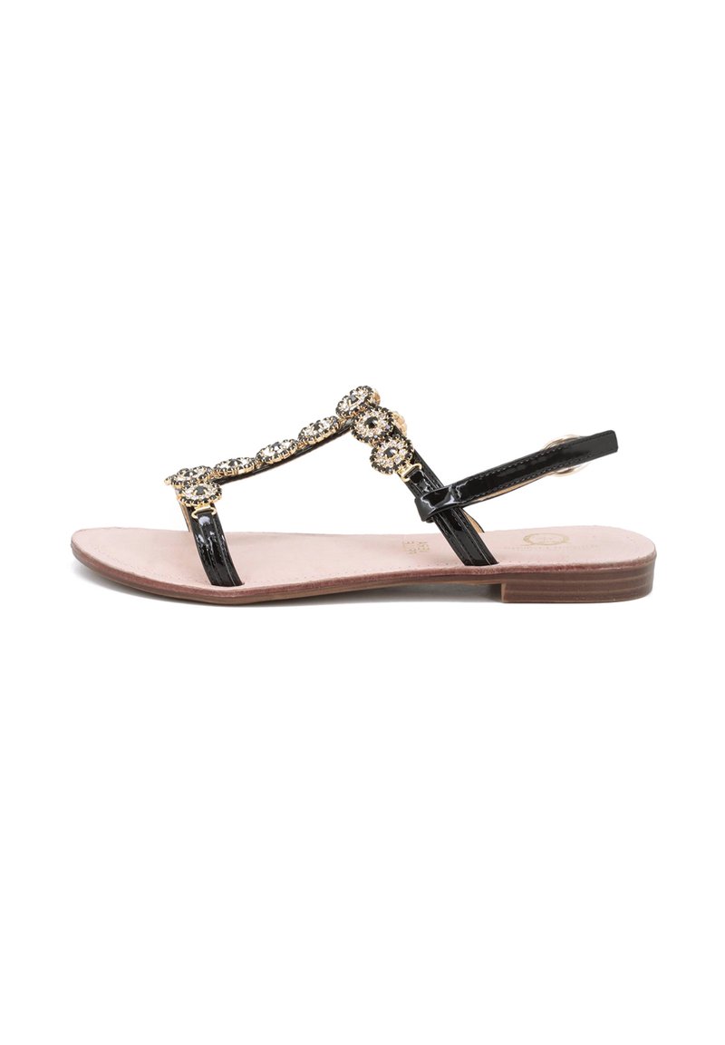 Sandal in pelle verniciata nera con decorazioni in oro e cristalli, suola piatta, design con fascia a T e soletta imbottita beige.