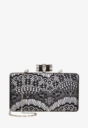 Pochette rectangulaire noire et blanche avec motif de dentelle complexe, fermeture argentée et bandoulière chaîne en argent attachée, sur fond blanc.