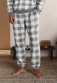 Grau-weiße karierten Flanell-Pyjama-Hosen mit elastischem Bund und Bündchen, ausgestattet mit Seitentaschen und einer weichen Textur.