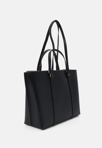 Czarna skórzana torba tote z dwoma długimi uchwytami, strukturalny design, gładka tekstura i subtelne akcenty w postaci przeszyć. Brak widocznych elementów metalowych.