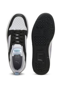 Sneaker bianco e nero con pelle bianca perforata, dettagli neri, suola in gomma texturizzata e linguetta sul tallone di colore azzurro chiaro.