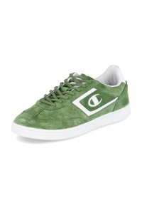 Zöld velúr sneaker fehér részletekkel és logóval, kerek orrral, lapos talppal és fűzős kialakítással. Puha textúrájú, sima felülettel.