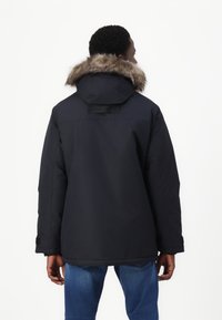 Mörkblå parkajacka med fodrad huva, designad med rak skärning och med ett detaljband bak.