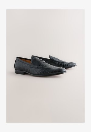 Melni ādas mokasīni ar krokodila rakstu, ar dekoratīvu siksniņu pār pēdas augšu un zemu, platu papēdi.