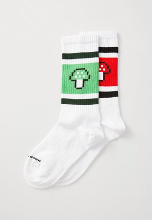 White crew socks featuring a green striped design with a pixelated green mushroom and a red striped design with a pixelated red mushroom.