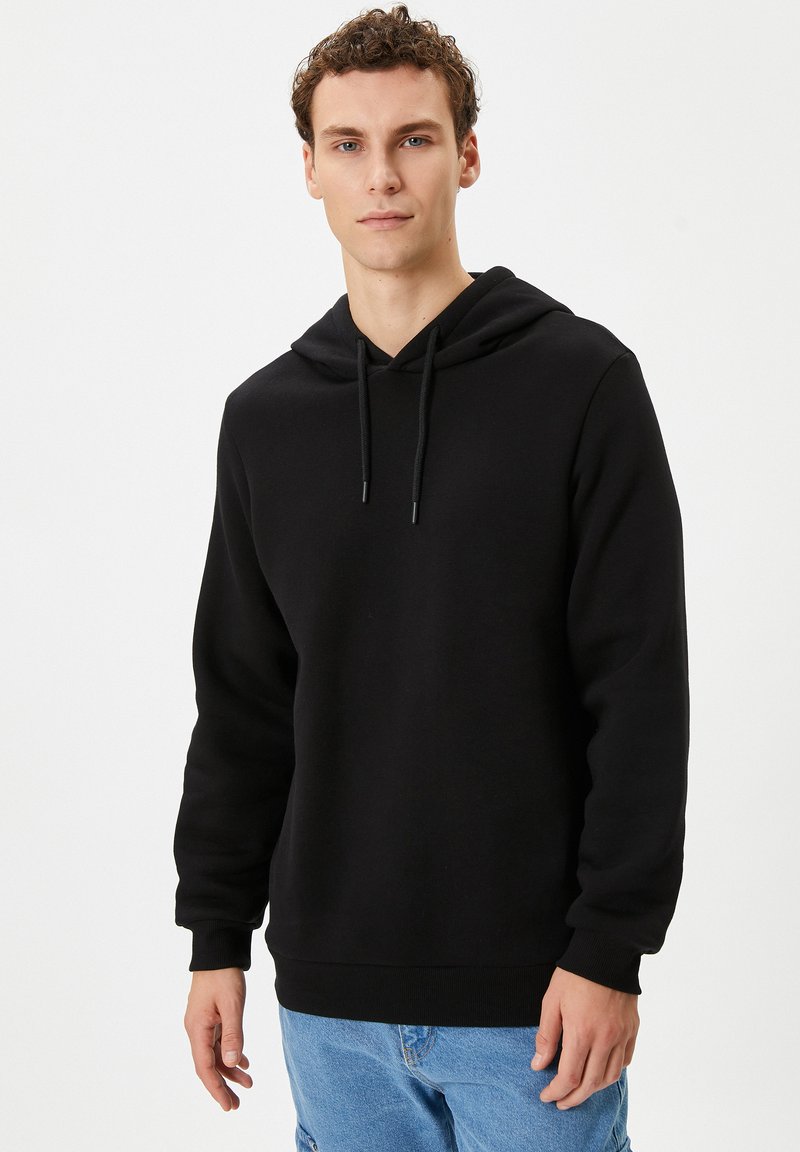 Zwarte pullover hoodie van zacht materiaal, met een trekkoordcapuchon, lange mouwen en ribgebreide manchetten en zoom. Casual fit met een minimalistisch ontwerp.
