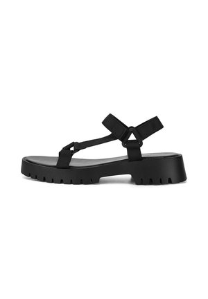 Black chunky sole sandal with adjustable nylon straps and an open toe, designed for casual outdoor wear.