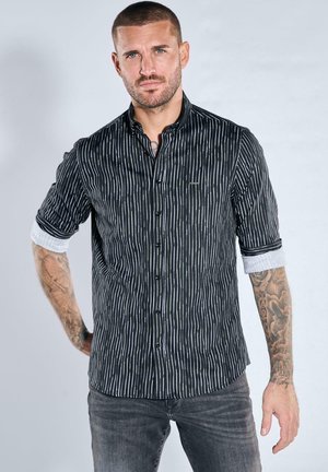 Schwarz-weiß gestreiftes Hemd mit Knopfleiste und hochgekrempelten Ärmeln, aus leichtem Stoff, mit tailliertem Schnitt und dezentem Logodetail.