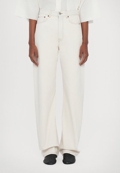 Hvide wide-leg jeans lavet af denim, med knaplukning, bæltestropper og en afslappet pasform. Blandet med sorte fodtøj.