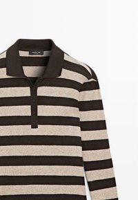 Langärmliges Poloshirt in beige und dunkelbraunen Streifen, mit Kragen und Knopfleiste mit drei Knöpfen. Weiche Textur, legeres Design.