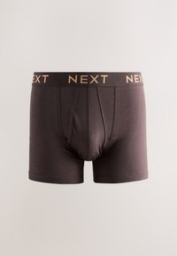 Boxer da uomo marrone scuro con vita elastica nera con la scritta "NEXT" in lettere beige, cuciture visibili sul pannello frontale.