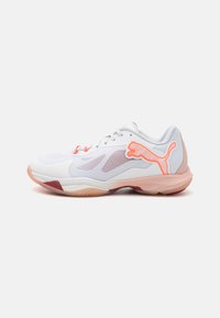 Scarpa sportiva bianca con dettagli in rete, suola rosa e logo arancione. Presenta una punta rotonda, lacci e un design snodato per il massimo comfort.