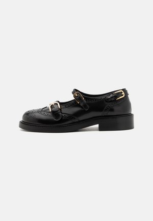 Chaussures en cuir noir avec détails de brogue, dotées de deux sangles à boucle, d'un bout arrondi et d'un talon bas. Texture lisse avec finition brillante.