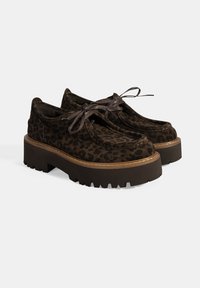 Braune Leopardenprint-Schuhe aus Wildleder, mit einer dicken, gerippten Sohle und flachen Schnürsenkeln, einem runden Zehendesign und kontrastierenden Nähten.