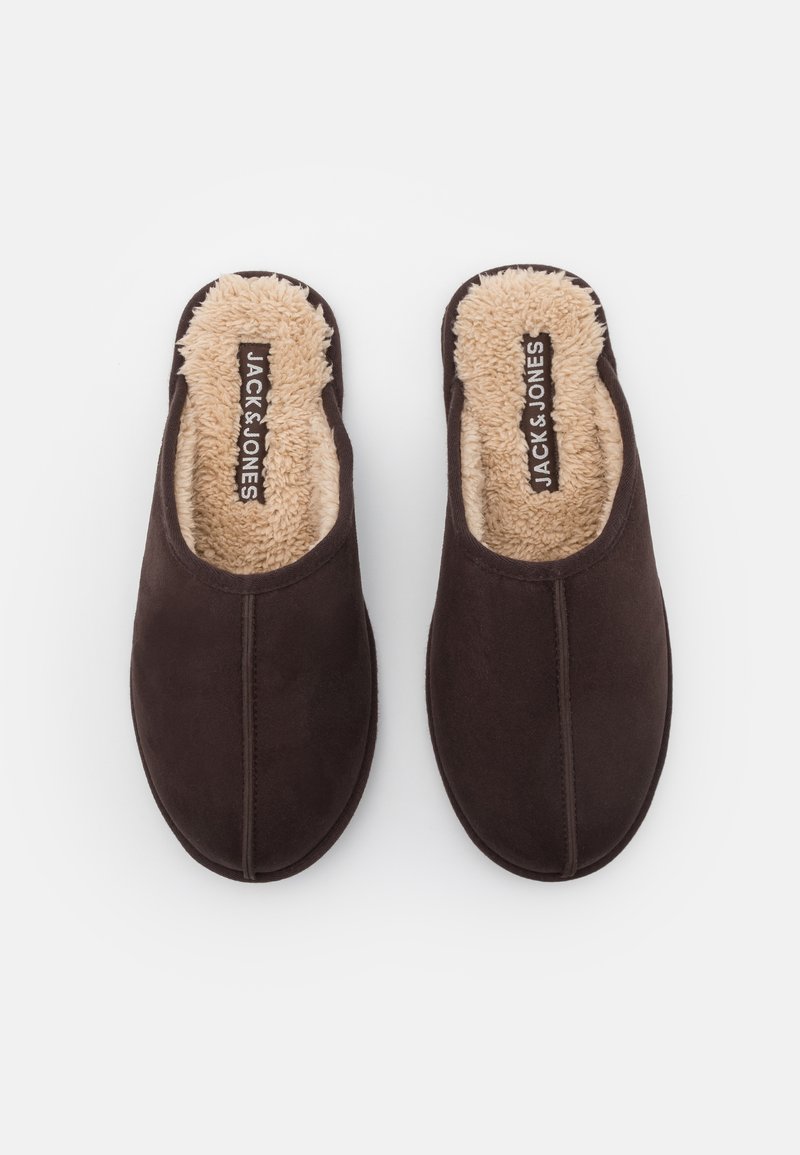 Zapatillas de ante marrón de tipo mocasín con un suave forro de piel sintética beige. Presentan costuras en la parte superior y una plantilla con la marca.
