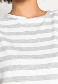 Grijs en wit gestreepte T-shirt met korte mouwen, met een brede halslijn en een zachte, gladde stof met een lichte structuur.