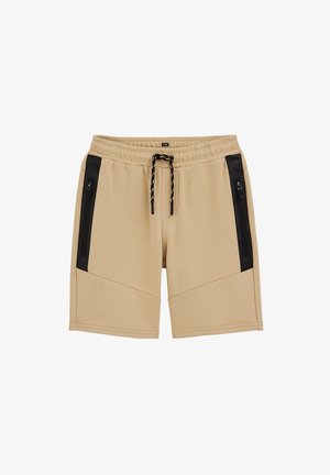 Pantaloncini beige con vita elastica, coulisse nera e tasche verticali con zip nere su ciascun lato.