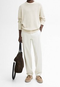 Maglione a maglia beige con orlo a coste, pantaloni cremo, borsa in suede marrone e sneakers color beige. Design semplice con vestibilità rilassata.