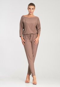 Loose, lightweight brown jumpsuit with three-quarter sleeves, off-the-shoulder neckline, and drawstring waist, featuring smooth, soft texture.
