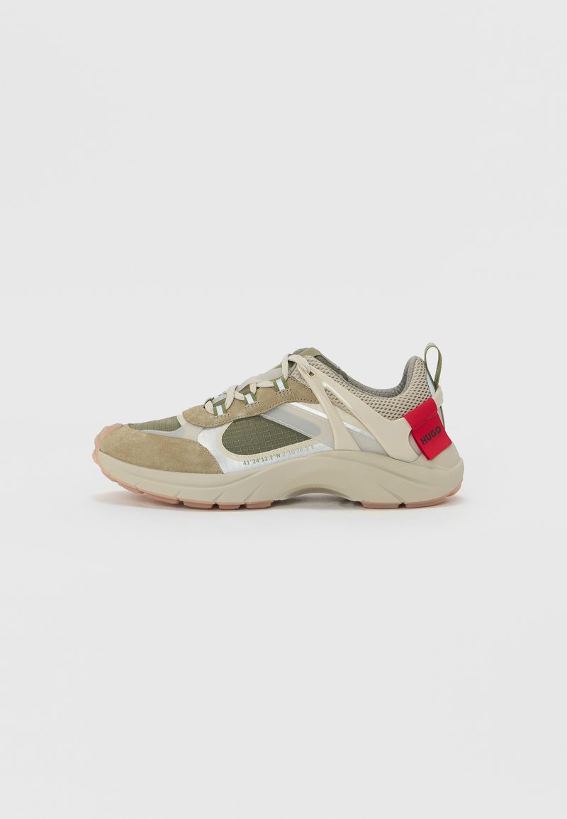 Urheilullinen lenkkari, jossa on khaki-värinen mokkanahka ja verkko-yläosa, heijastavat yksityiskohdat, beige välipohja ja punainen logokohta kantapäässä.