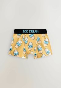 Shorts boxer jaunes avec un motif de cornets de glace souriants en bleu et blanc, et une ceinture noire portant l'inscription "ICE CREAM" en lettres bleues.