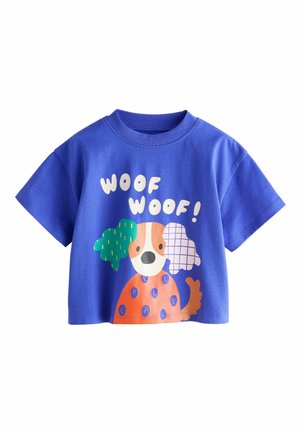 Sinine puuvillane t-särk mängulise koera kujutisega, millel on rohelised ja mustrilised aksendid. Tekst "WOOF WOOF!" on valges värvis. Lühikesed varrukad.