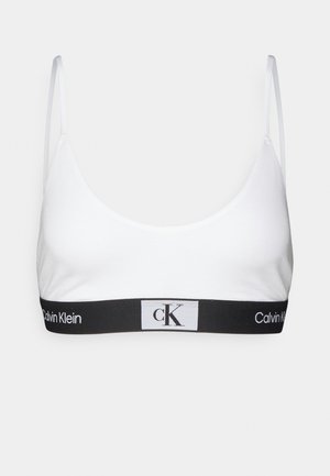 Bralet alb din bumbac cu bretele subțiri, având un band elastic negru pe care sunt afisate proeminent logo-urile "Calvin Klein" și "ck".