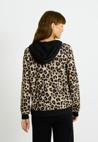 Sudadera de estampado de leopardo con capucha negra, con mangas largas y un corte holgado, fabricada en un tejido suave y texturizado.