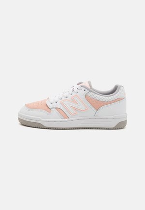 Weiße und rosa Sportschuhe mit einem Obermaterial aus Leder und Wildleder, ausgestattet mit perforierten Akzenten, einer gepolsterten Einlegesohle und einer Gummisohle.