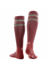 Calze rosse alte fino al ginocchio con strisce verdi in cima. Realizzate in tessuto testurizzato, presentano dettagli imbottiti e un logo sul lato.