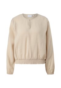 Blouse beige à manches longues avec col rond, petite ouverture en forme de clé avec des boutons, et taille et poignets élastiqués.