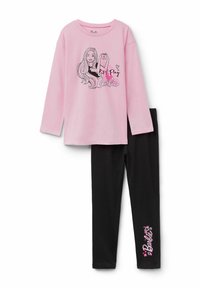 Růžová dlouhá halenka s grafikou "Pojďme si hrát na Barbiu", zkombinovaná s černými legínami obsahujícími text "Barbie" a srdíčkovými akcenty.