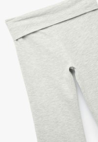 Harmaat legginsit, jotka on valmistettu pehmeästä, joustavasta kankaasta. Niissä on leveä, sileä vyötärönauha ja saumaton muotoilu, jossa ei ole näkyviä yksityiskohtia tai kuvioita.