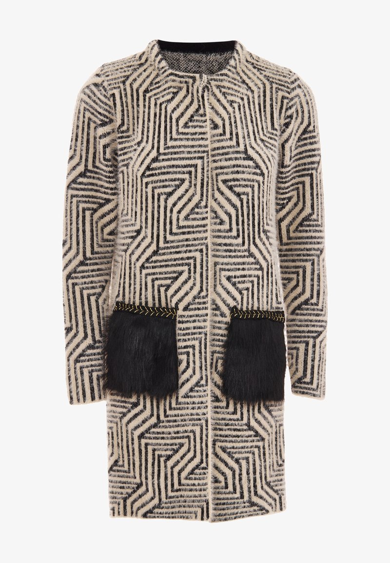 Fekete és krémszínű, geometrikus mintázatú kabát, két fekete szőr zsebbel és arany varrással a zsebek peremén.