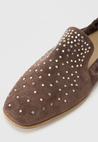 Καφέ σουέντ παπούτσι τύπου slip-on με στρογγυλεμένη μύτη, διακοσμημένο με διασκορπισμένα στρας στην επάνω επιφάνεια.
