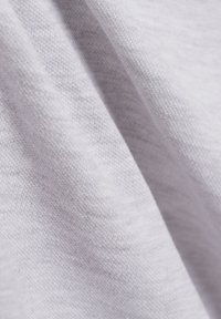 Lichtgrijze stof met een zachte, gladde textuur en een fijn geweven patroon. Het materiaal lijkt lichtgewicht en heeft een lichte reflectie.