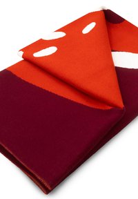 Szydełkowany szal w intensywnym pomarańczowym i głębokim burgundzie, z abstrakcyjnymi białymi kształtami oraz złożonym projektem, który podkreśla jego miękką teksturę.