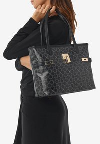 Borsa tote nera a tracolla con motivo, realizzata in materiale testurizzato, dotata di hardware dorato e un design elegante e strutturato con due manici robusti.