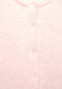 Cardigan rose clair présentant un tricot doux et texturé, un col rond et six boutons assortis à l'avant.