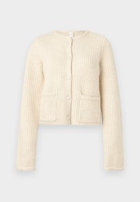 Gekürzter cremefarbener Cardigan, strukturierter Stoff mit vertikaler Rippung, Knopfverschluss vorne und zwei aufgesetzten Taschen.