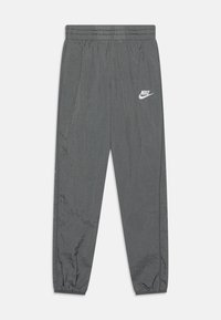 Sive Nike trenirke s elastičnim pojasom, manžetama na rubovima i malim bijelim logom na lijevom butu. Glatki, lagani materijal.