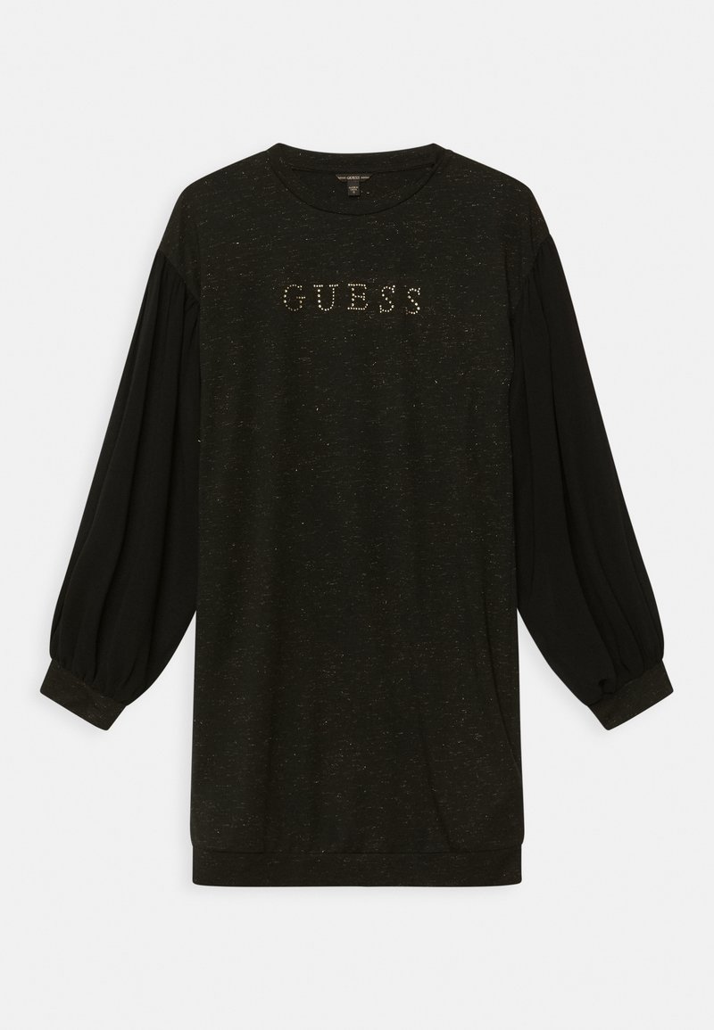 Haut noir à manches longues avec un col rond et des poignets côtelés. Présente un logo "GUESS" en clous métalliques sur le devant. Texture douce, coupe décontractée.
