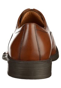 Chaussure de ville en cuir marron vue de l'arrière, montrant les détails de couture et la semelle noire sur un fond blanc.