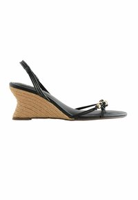 Sandale compensée avec talon en corde tressée couleur biscuit, semelle en cuir noir, fines lanières noires et détails de perles dorées sur la bride des orteils.