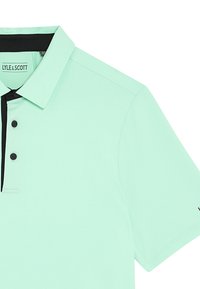 Ljusmyntgrön polo skjorta i smidigt tyg, med klassisk krage, tre knappar och svarta detaljer längs knapplisten och ärmen.